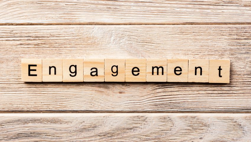 alt=image that displays the word engagement out using scrabble pieces on the background of a wooden panel"